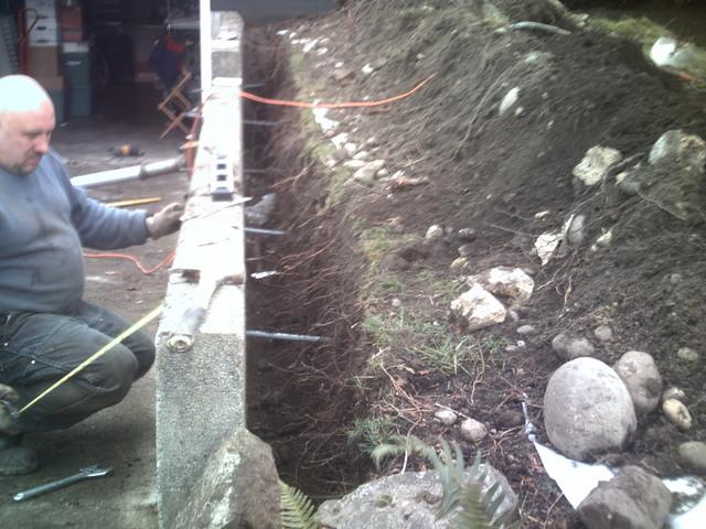 Steel rods extending through retaining wall and wall plates.